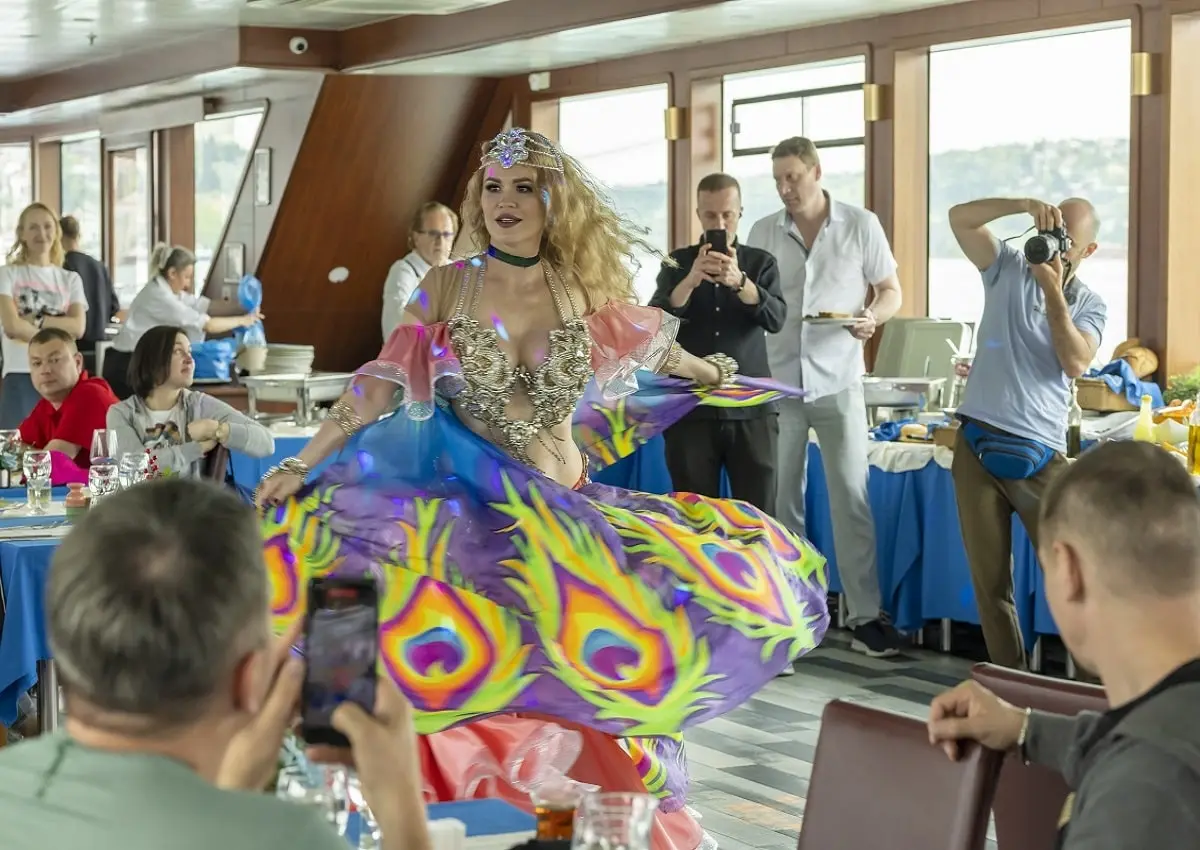 People enjoying around a belly dancer on a Bosphorus cruise