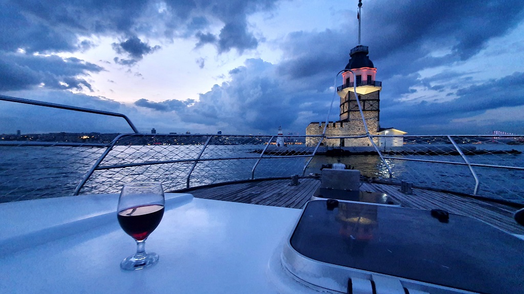 A glass of wine on a Elite yacht deck overlooking the Bosphorus view at sunset